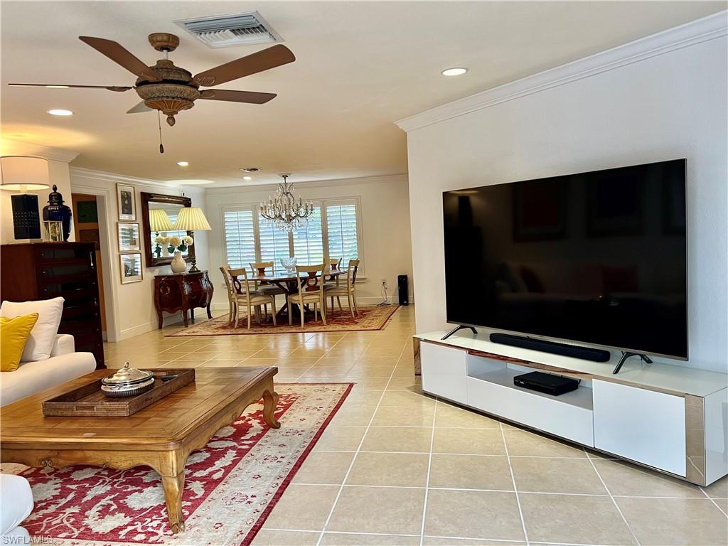 283 Cypress Way West Naples, FL 34110 - Photo 10 of 18 Tiled living area with a chandelier and crown molding