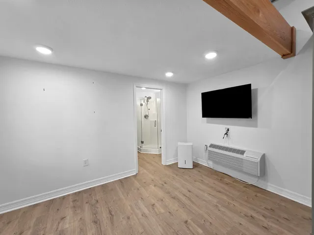 a view of a livingroom with wooden floor and flat screen tv