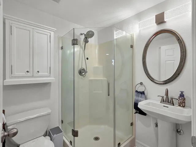 a bathroom with a sink a toilet and a mirror