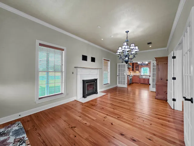 a view of a livingroom with wooden floor fireplace and window