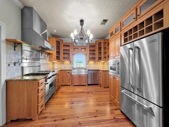 a kitchen with stainless steel appliances granite countertop a refrigerator a stove top oven a sink and dishwasher