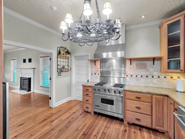 a kitchen with stainless steel appliances granite countertop a stove oven and a wooden floors