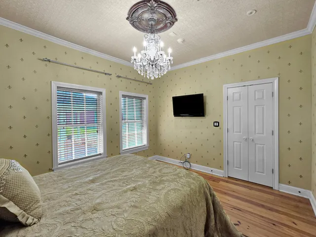 a spacious bedroom with a bed and a chandelier