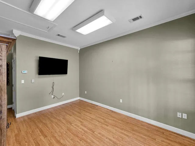 a view of a livingroom with wooden floor and a flat screen tv