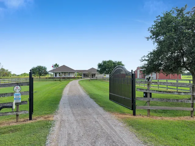 a green field with lots of trees in the background
