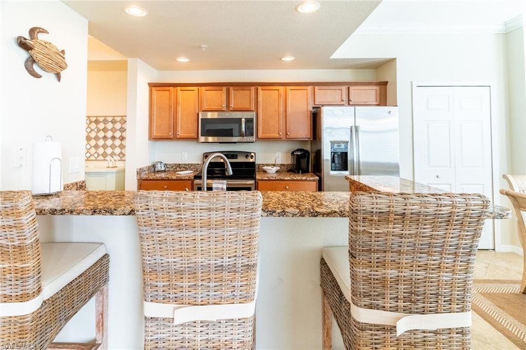 9731 Acqua Court, Unit 536 Naples, FL 34113 - Photo 14 of 48 a kitchen with stainless steel appliances wooden floor and a large window