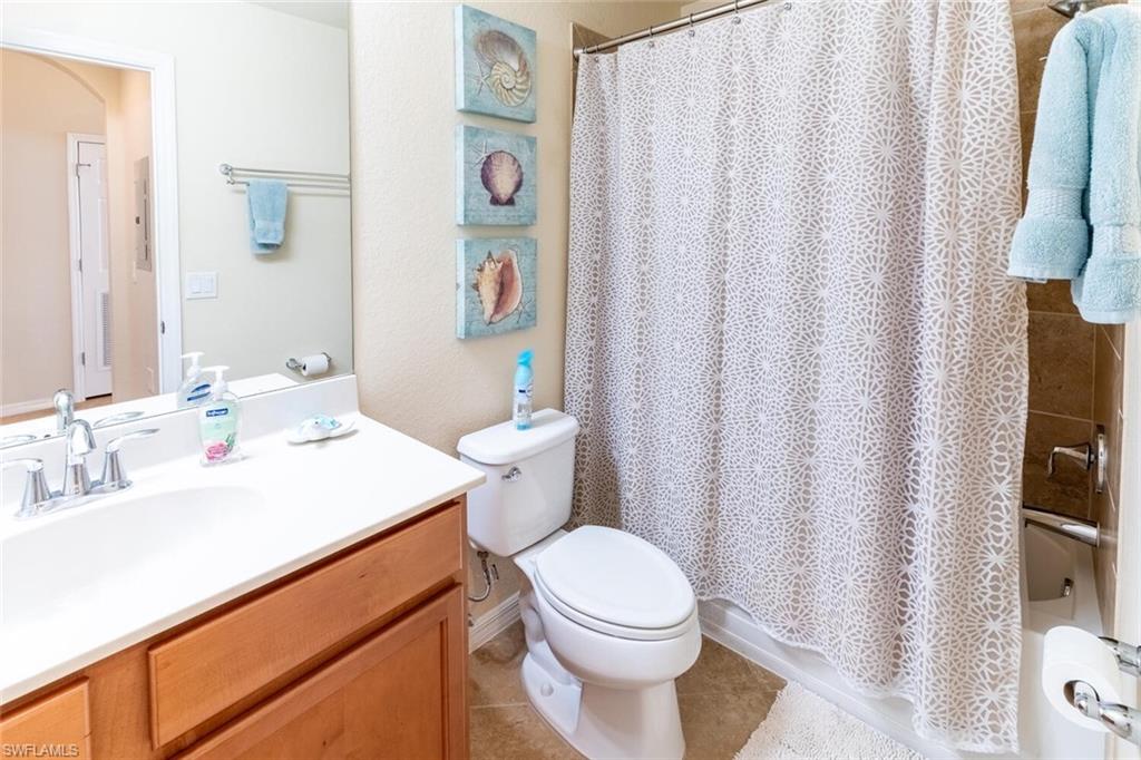 9731 Acqua Court, Unit 536 Naples, FL 34113 - Photo 23 of 48 a bathroom with a sink a toilet and shower curtain
