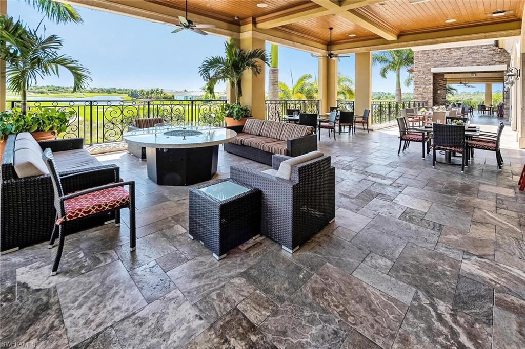9731 Acqua Court, Unit 536 Naples, FL 34113 - Photo 44 of 48 a living room with patio furniture and a floor to ceiling window