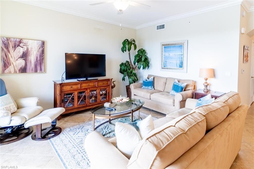 9731 Acqua Court, Unit 536 Naples, FL 34113 - Photo 6 of 48 a living room with furniture and a flat screen tv