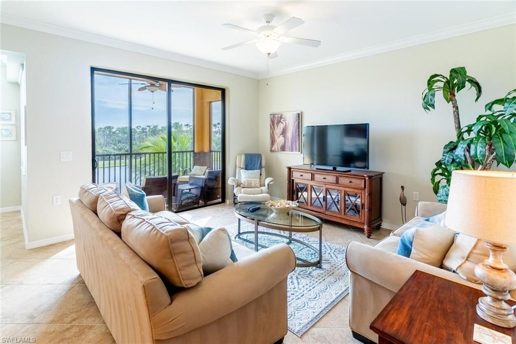 9731 Acqua Court, Unit 536 Naples, FL 34113 - Photo 7 of 48 a living room with furniture a flat screen tv and a large window