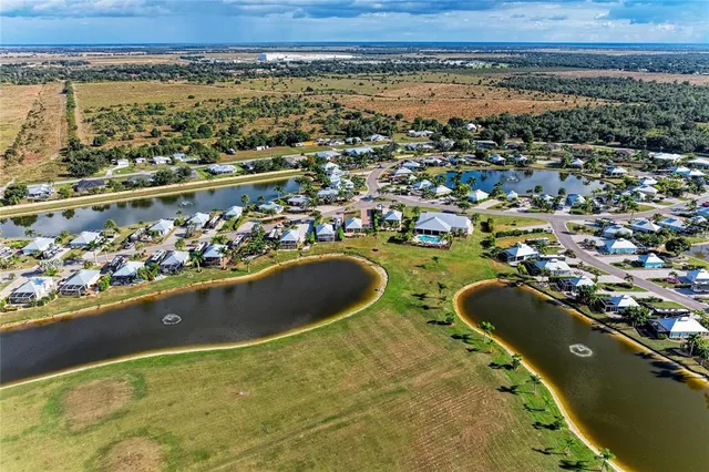 an aerial view of ocean and residential houses with outdoor space
