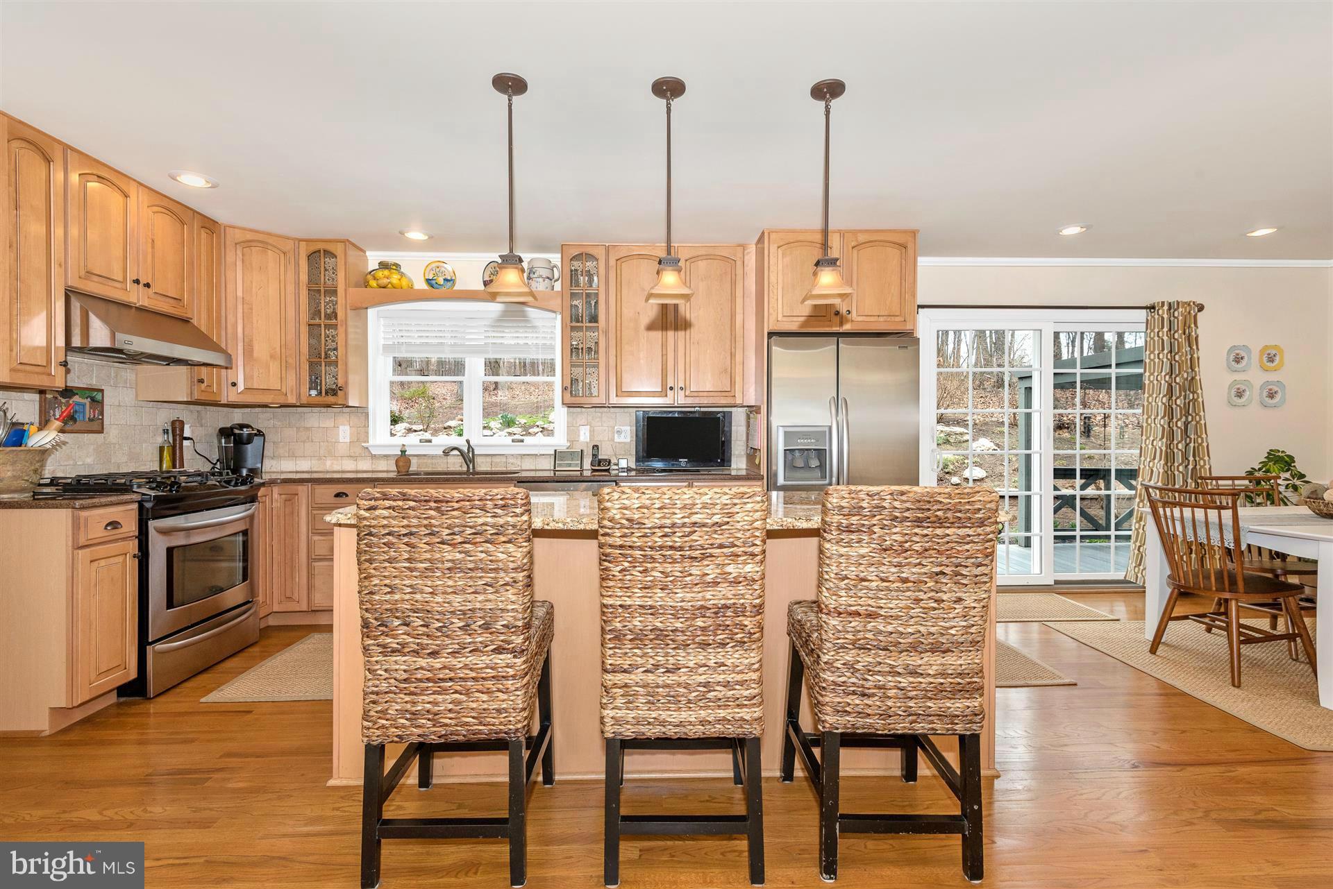 4230 Basford Road Frederick, MD 21703 - Photo 16 of 30 a kitchen with stainless steel appliances kitchen island granite countertop a table chairs and a view of living room