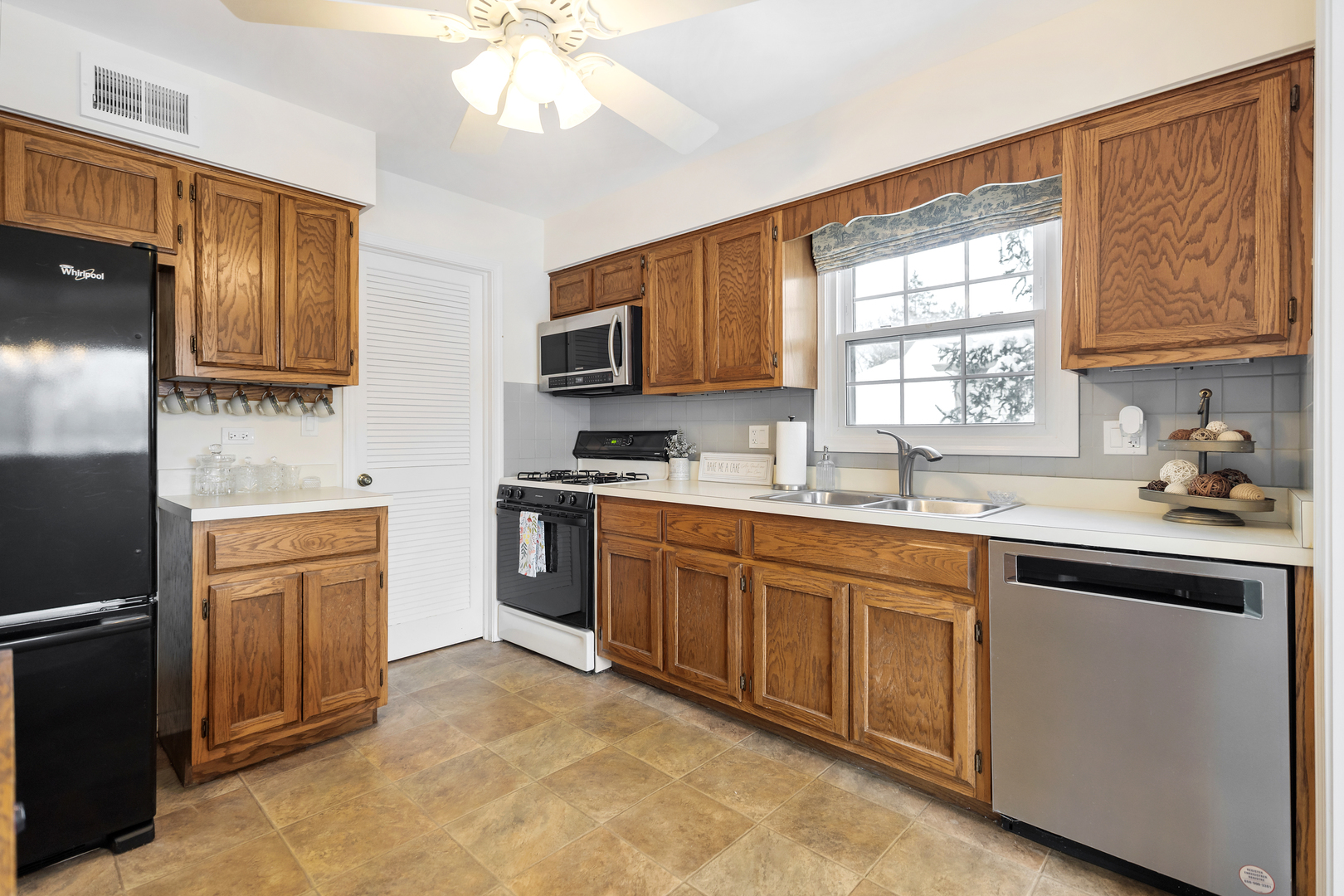 1907 Gresham Circle, Unit D Wheaton, IL 60189 - Photo 11 of 26 a kitchen with a sink stove and microwave