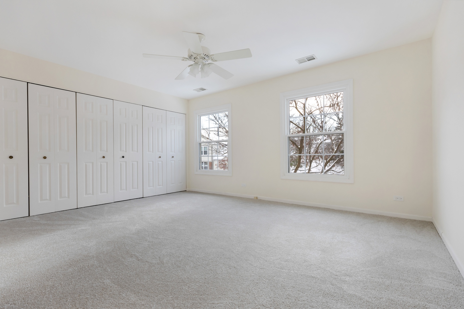 1907 Gresham Circle, Unit D Wheaton, IL 60189 - Photo 15 of 26 an empty room with windows and chandelier fan