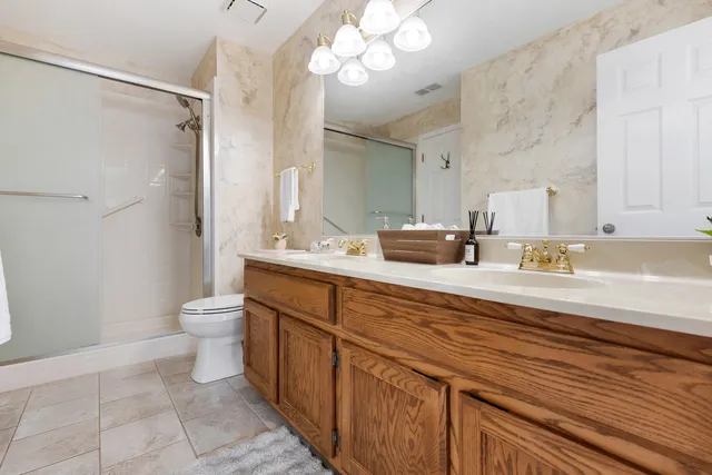 a bathroom with a sink a toilet and a large mirror