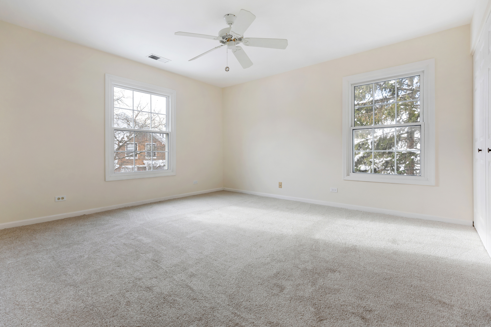 1907 Gresham Circle, Unit D Wheaton, IL 60189 - Photo 18 of 26 an empty room with windows and fan