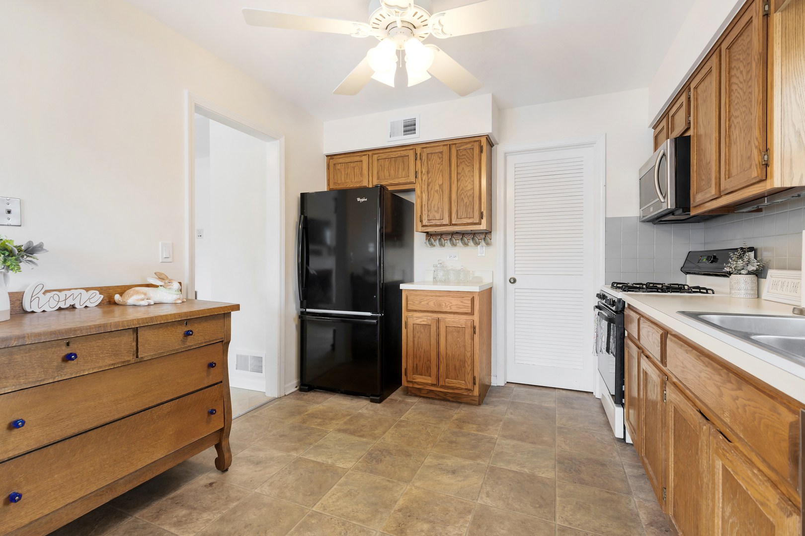 1907 Gresham Circle, Unit D Wheaton, IL 60189 - Photo 10 of 26 a kitchen with stainless steel appliances a refrigerator sink and cabinets
