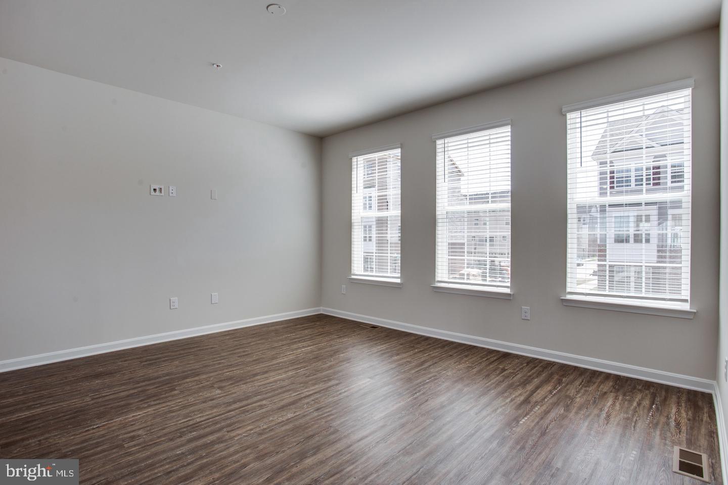 7068 Delegate Place Frederick, MD 21703 - Photo 22 of 76 a view of an empty room with wooden floor and a window