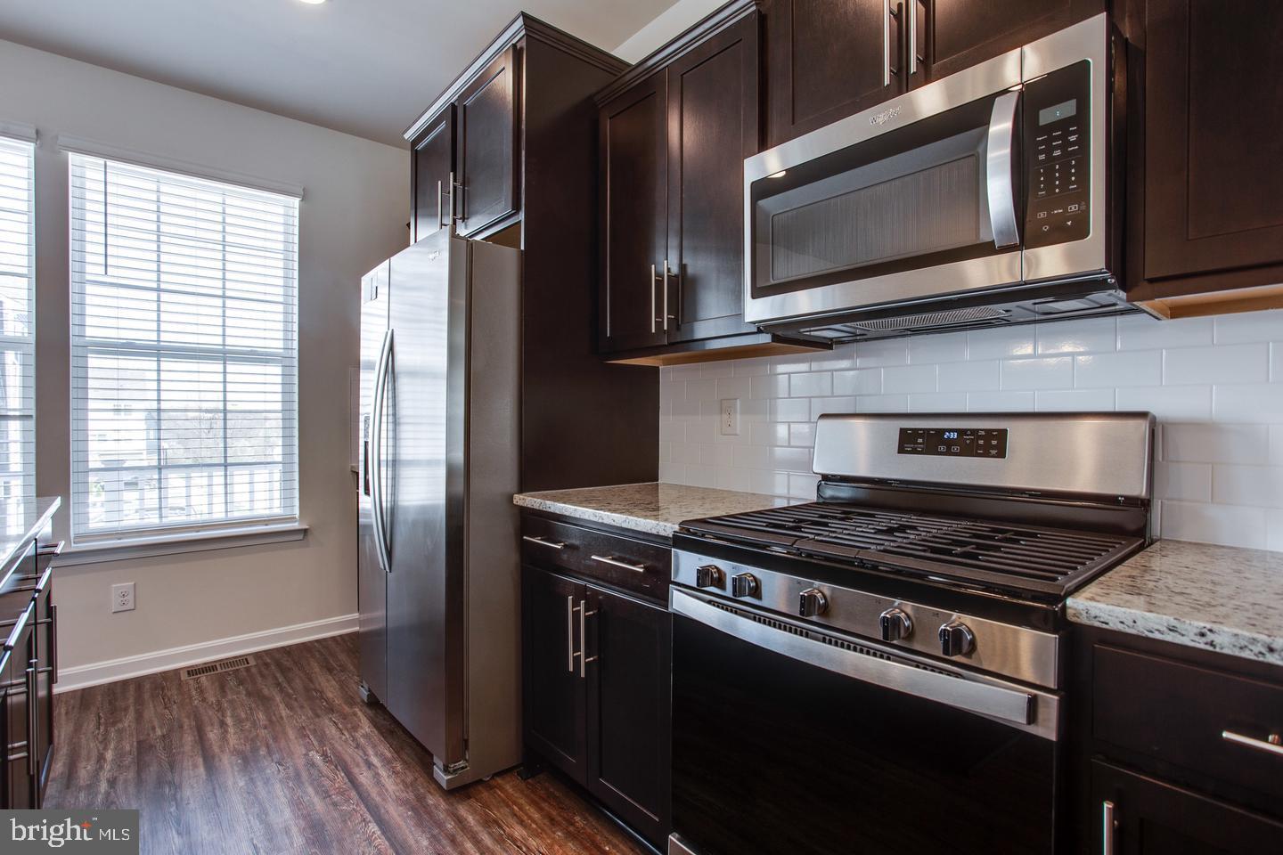 7068 Delegate Place Frederick, MD 21703 - Photo 27 of 76 a kitchen with stainless steel appliances granite countertop a stove microwave and refrigerator