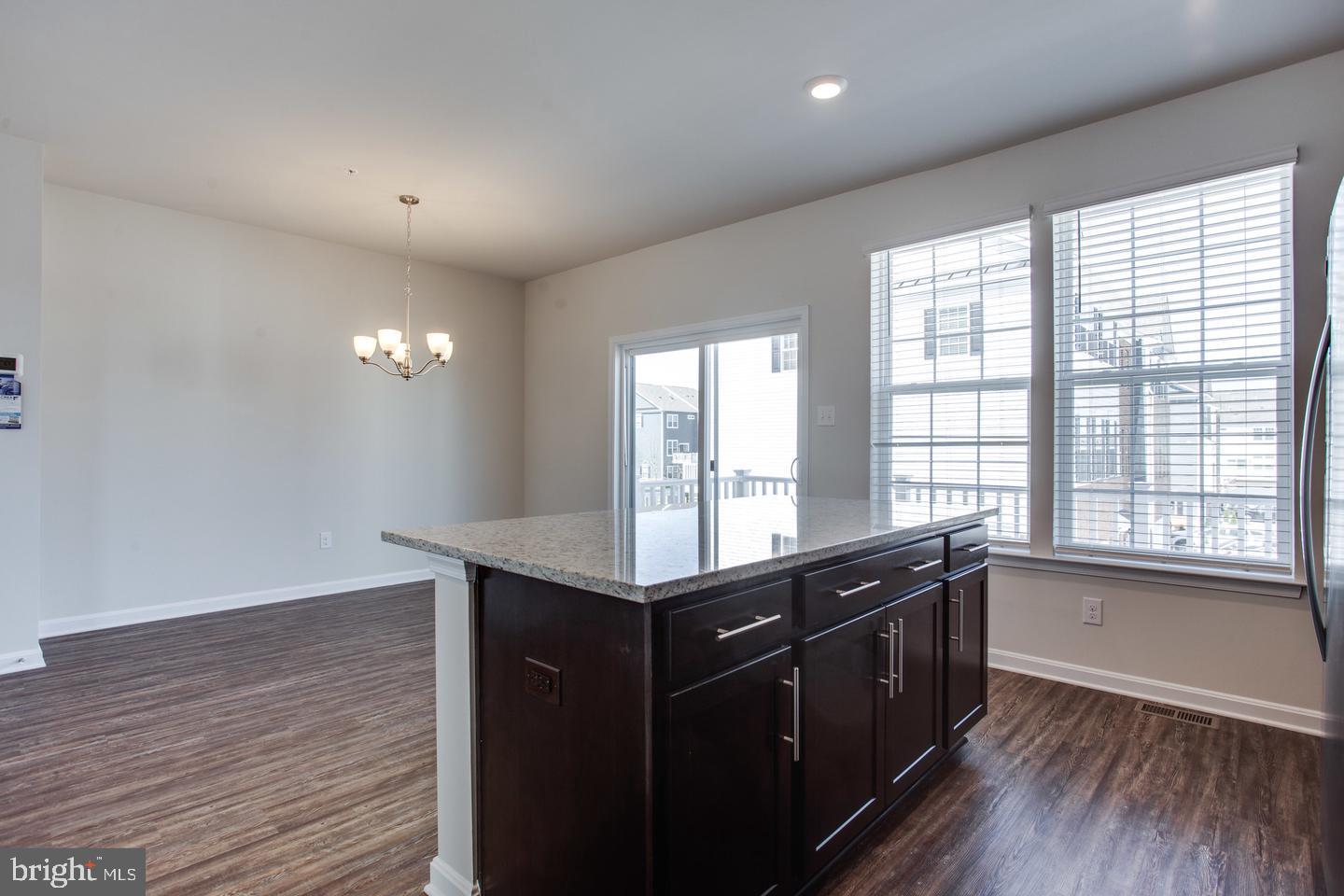 7068 Delegate Place Frederick, MD 21703 - Photo 29 of 76 a kitchen with granite countertop a stove a sink and wooden floor