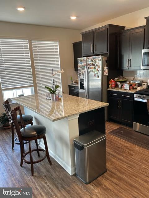 7068 Delegate Place Frederick, MD 21703 - Photo 32 of 76 a kitchen with stainless steel appliances kitchen island granite countertop a table chairs and a refrigerator
