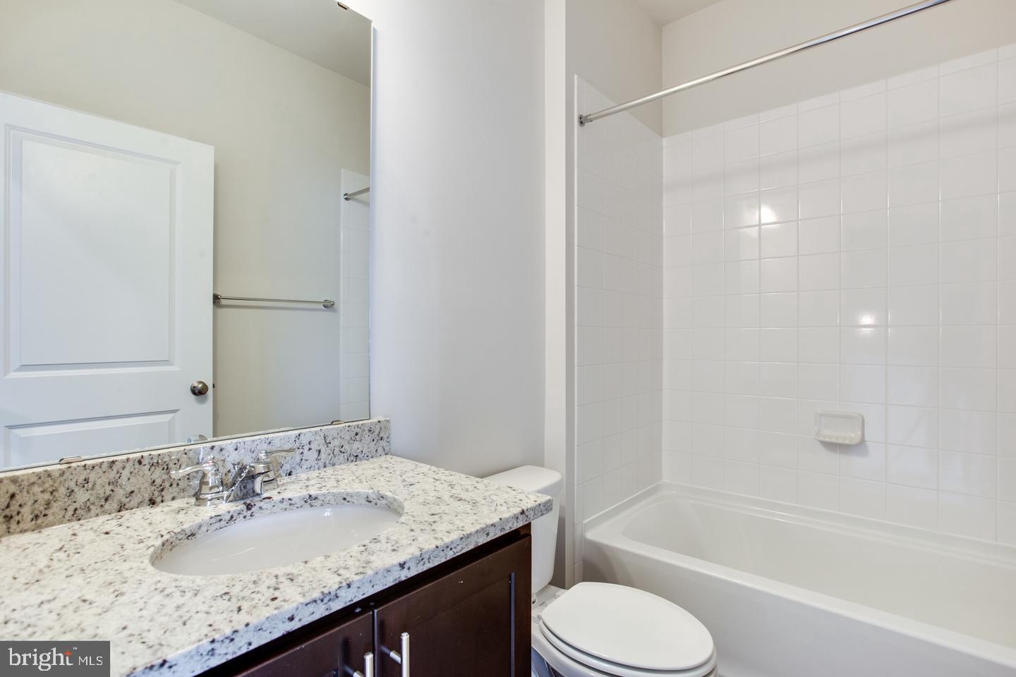 7068 Delegate Place Frederick, MD 21703 - Photo 45 of 76 a bathroom with a granite countertop sink toilet and shower
