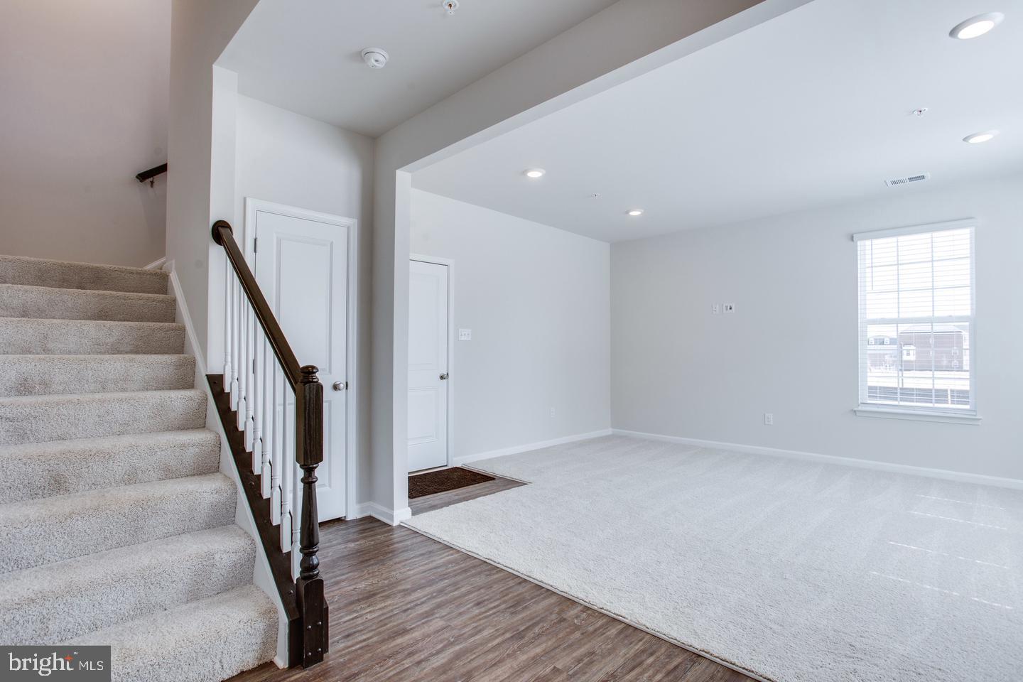 7068 Delegate Place Frederick, MD 21703 - Photo 8 of 76 a view of an empty room with wooden floor and stairs
