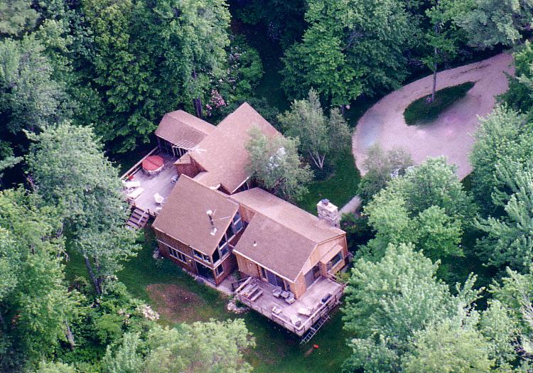an aerial view of a house with garden space and street view