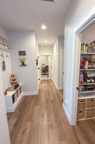 a view of a living room hardwood floor and an empty room