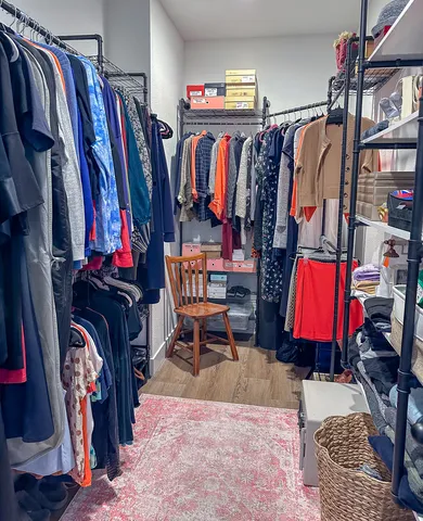 a view of walk in closet with clothes and shoes