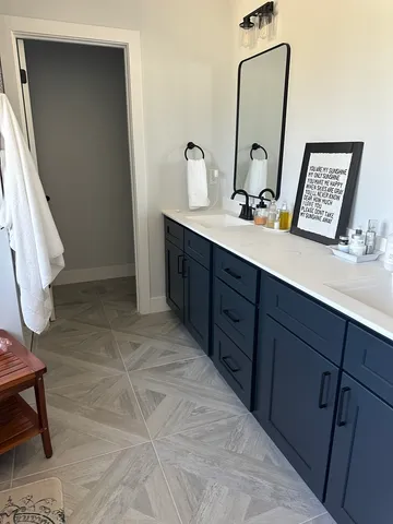 a bathroom with a double vanity sink and a mirror