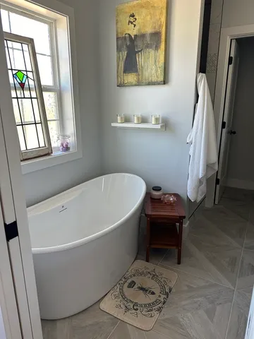 a white bath tub sitting next to a window