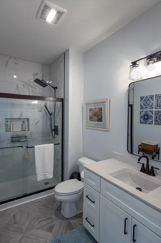 a bathroom with a sink mirror vanity and toilet