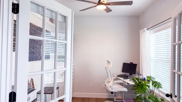 a view of a workspace with furniture and a window