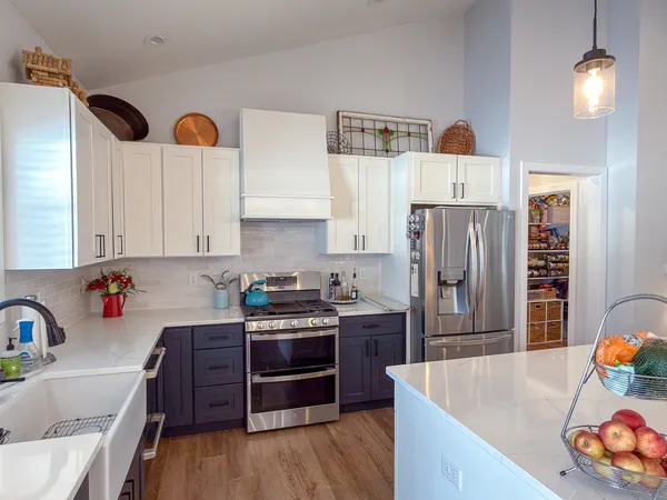 a kitchen with stainless steel appliances a stove a sink a refrigerator and cabinets