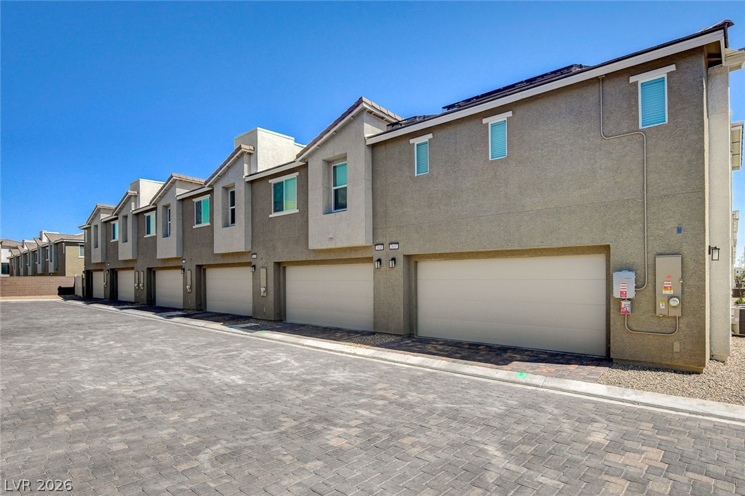 6924 Spicy Merlot Street North Las Vegas, NV 89086 - Photo 64 of 83 Rows of attached garages and a neatly paved driveway define this contemporary residential facade.