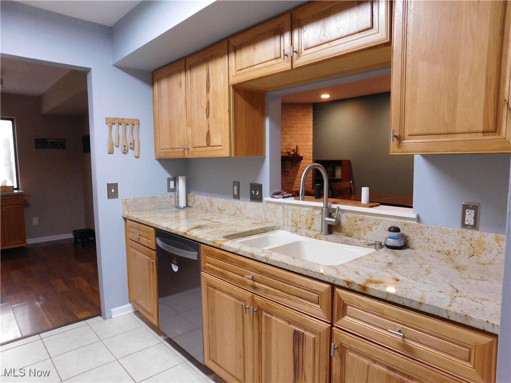 987 Hampton Ridge Drive Akron, OH 44313 - Photo 19 of 49 Kitchen with granite countertops, light tile patterned floors, and dishwasher