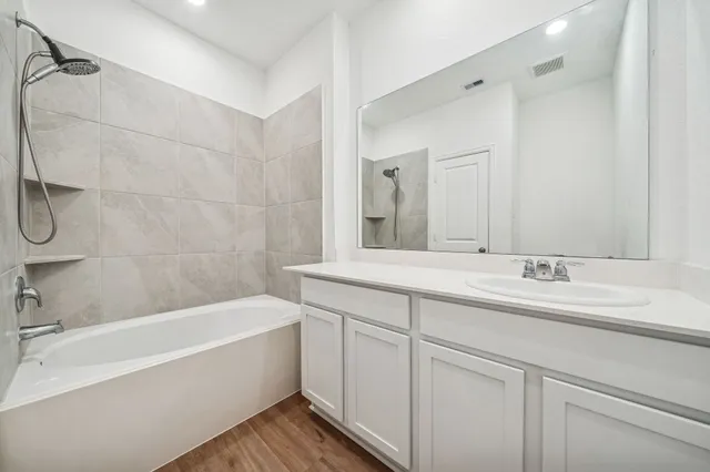 a bathroom with a tub sink and mirror