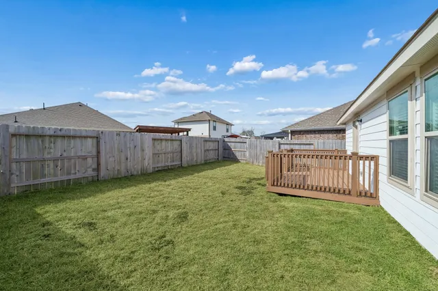 a view of a backyard with wooden fence