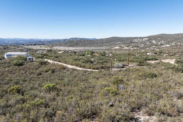 a view of a dry yard with mountains in the background