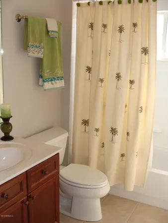 a bathroom with a sink a toilet and shower curtain