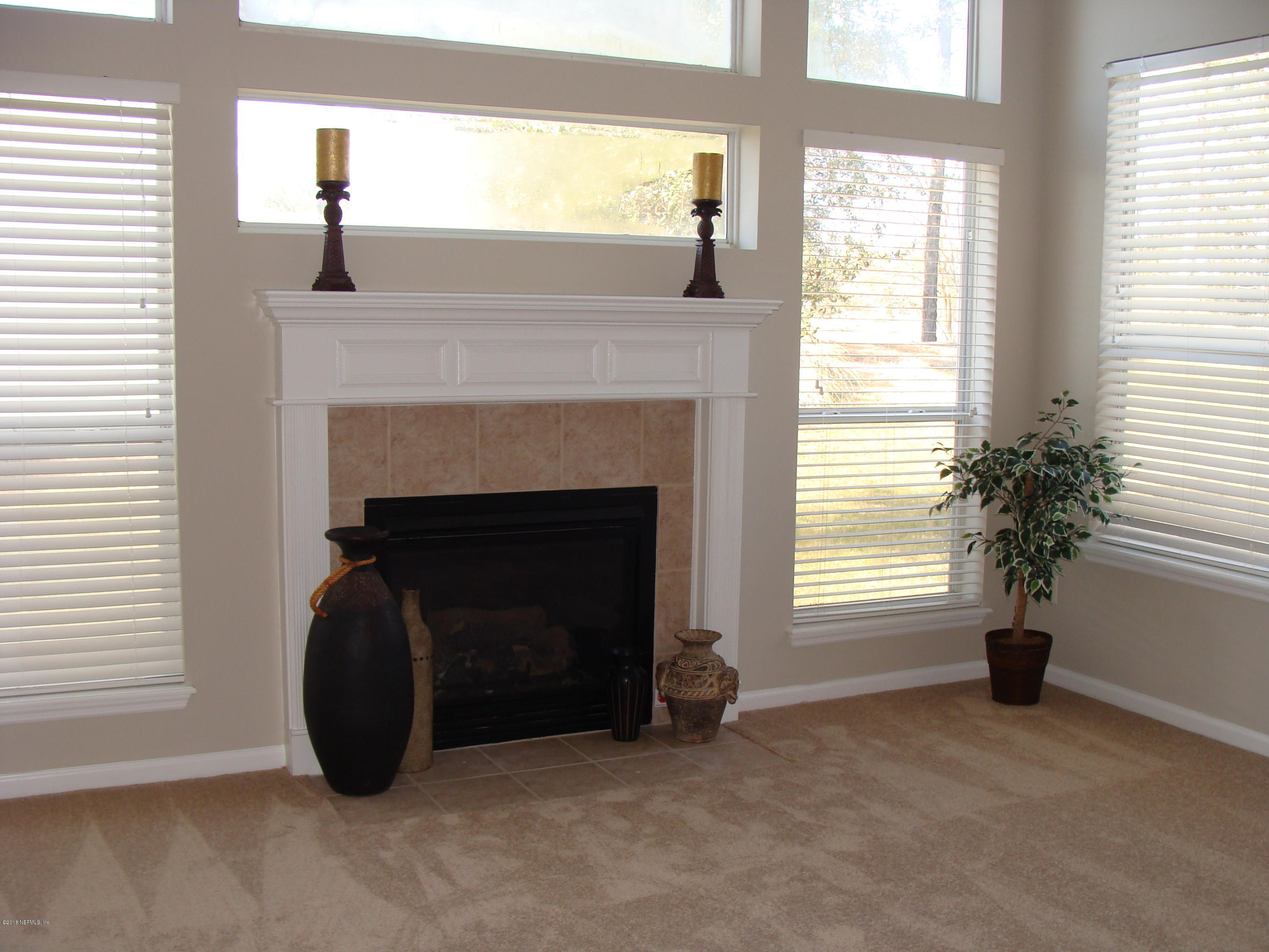 258 Porta Rosa Circle St. Augustine, FL 32092 - Photo 19 of 37 a living room with a fireplace and windows
