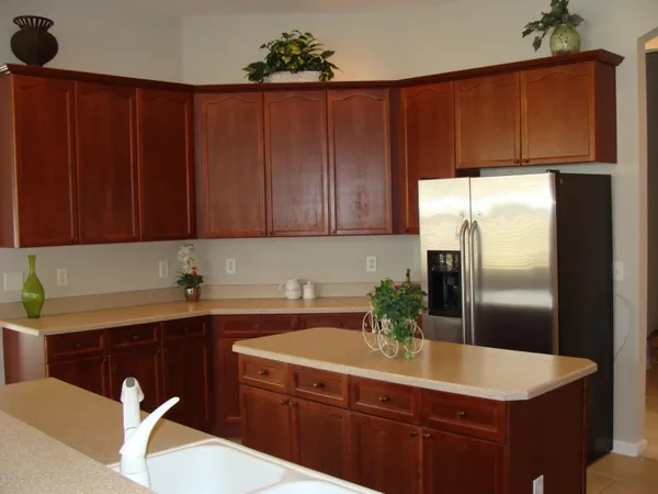 a view of kitchen with stainless steel appliances granite countertop refrigerator sink and wooden cabinets