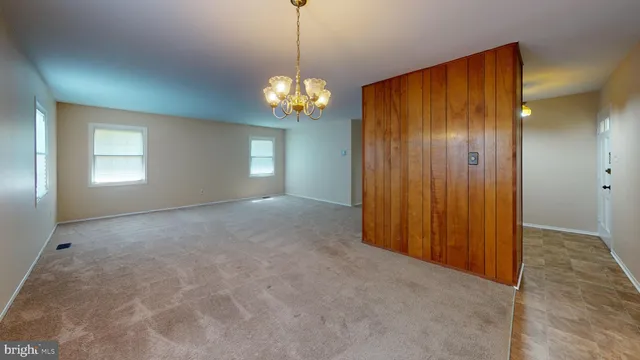 a view of a livingroom with a chandelier fan and windows
