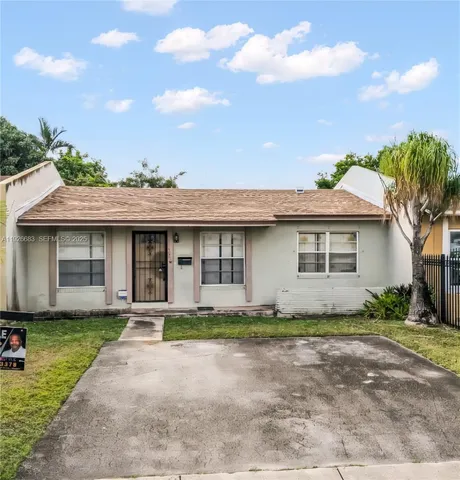 a front view of a house with a garden and yard