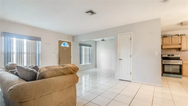 a living room with furniture and a open kitchen view