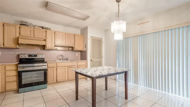 a kitchen with stainless steel appliances granite countertop a stove top oven a sink dishwasher and a refrigerator with wooden cabinets