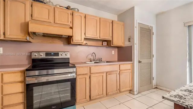 a kitchen with stainless steel appliances granite countertop a stove and a white cabinets