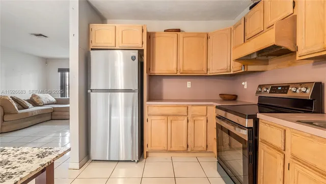 a kitchen with stainless steel appliances granite countertop a refrigerator sink and cabinets