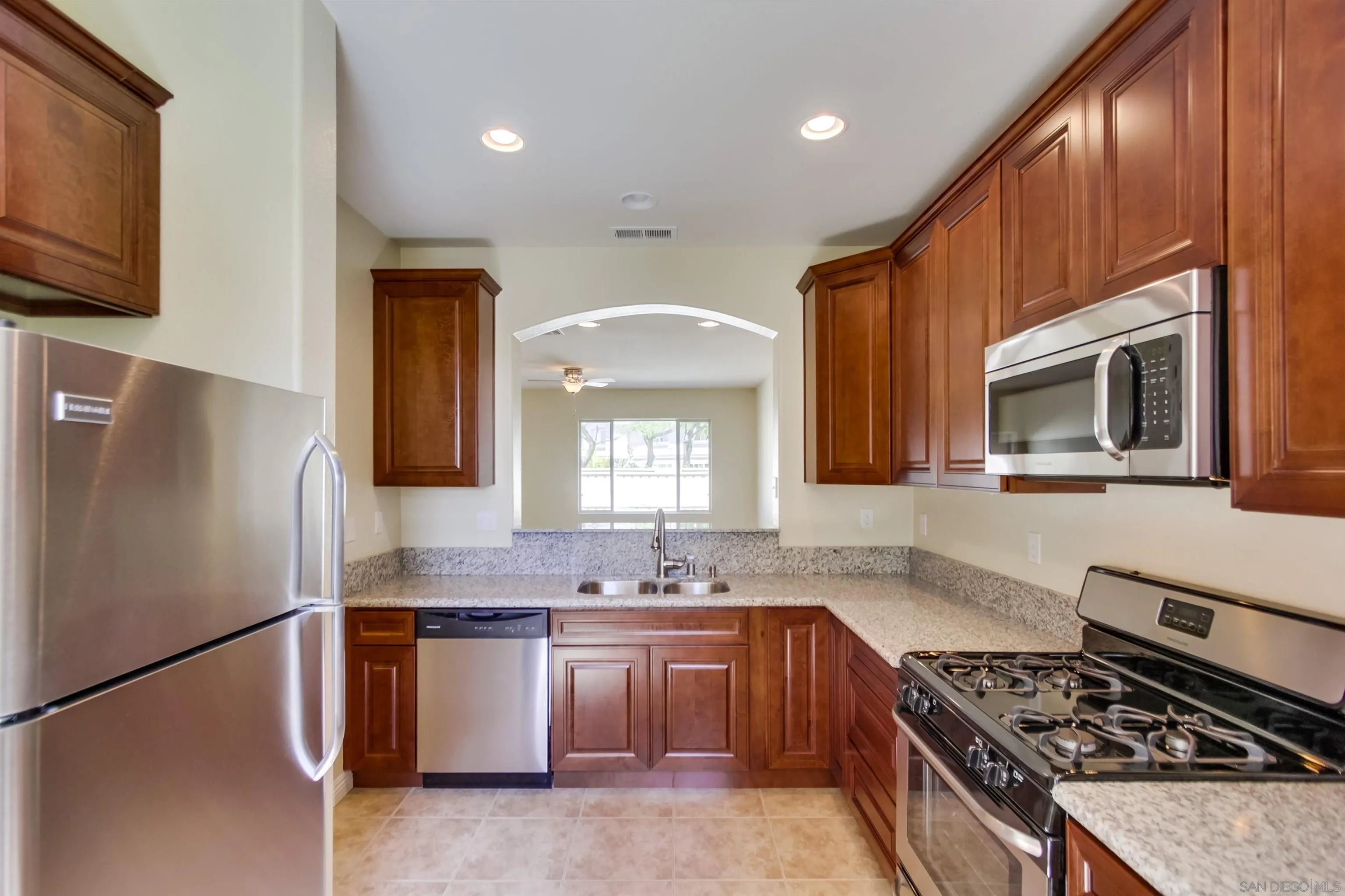 1201 Trapani Cove, Unit 4 Chula Vista, CA 91915 - Photo 7 of 37 a kitchen with stainless steel appliances granite countertop a stove a sink and a microwave